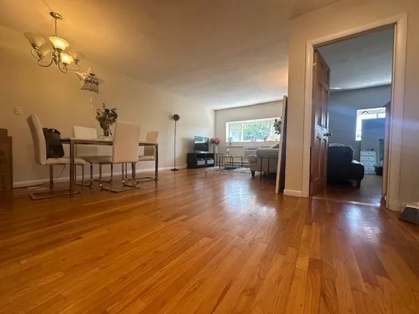 a view of a livingroom with furniture wooden floor a chandelier