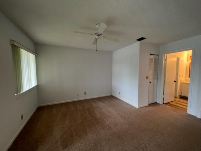 6532 Chasewood Drive, Unit F Jupiter, FL 33458 - Photo 15 of 17 an empty room with a window and a ceiling fan