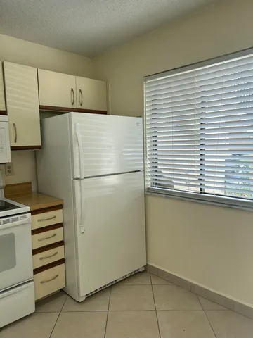 a white refrigerator freezer and a stove sitting inside of a kitchen
