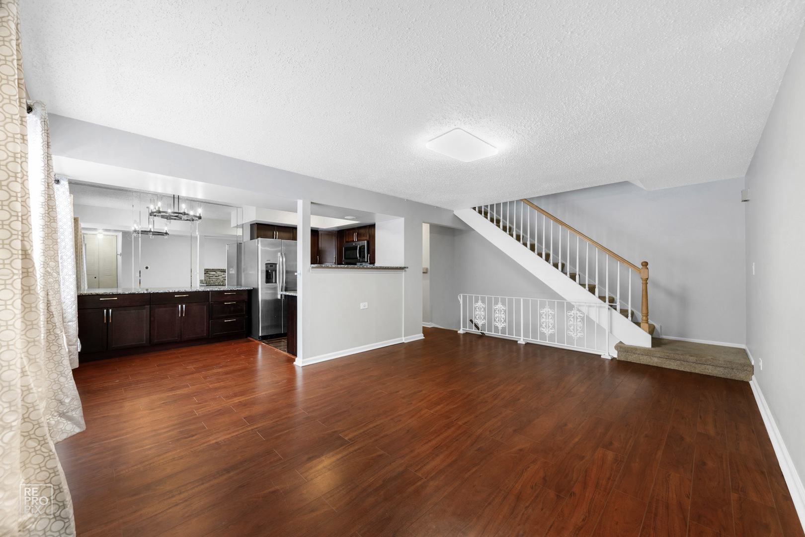 1306 Inverrary Lane, Unit 1306 Deerfield, IL 60015 - Photo 2 of 12 a view of an empty room with wooden floor and a kitchen