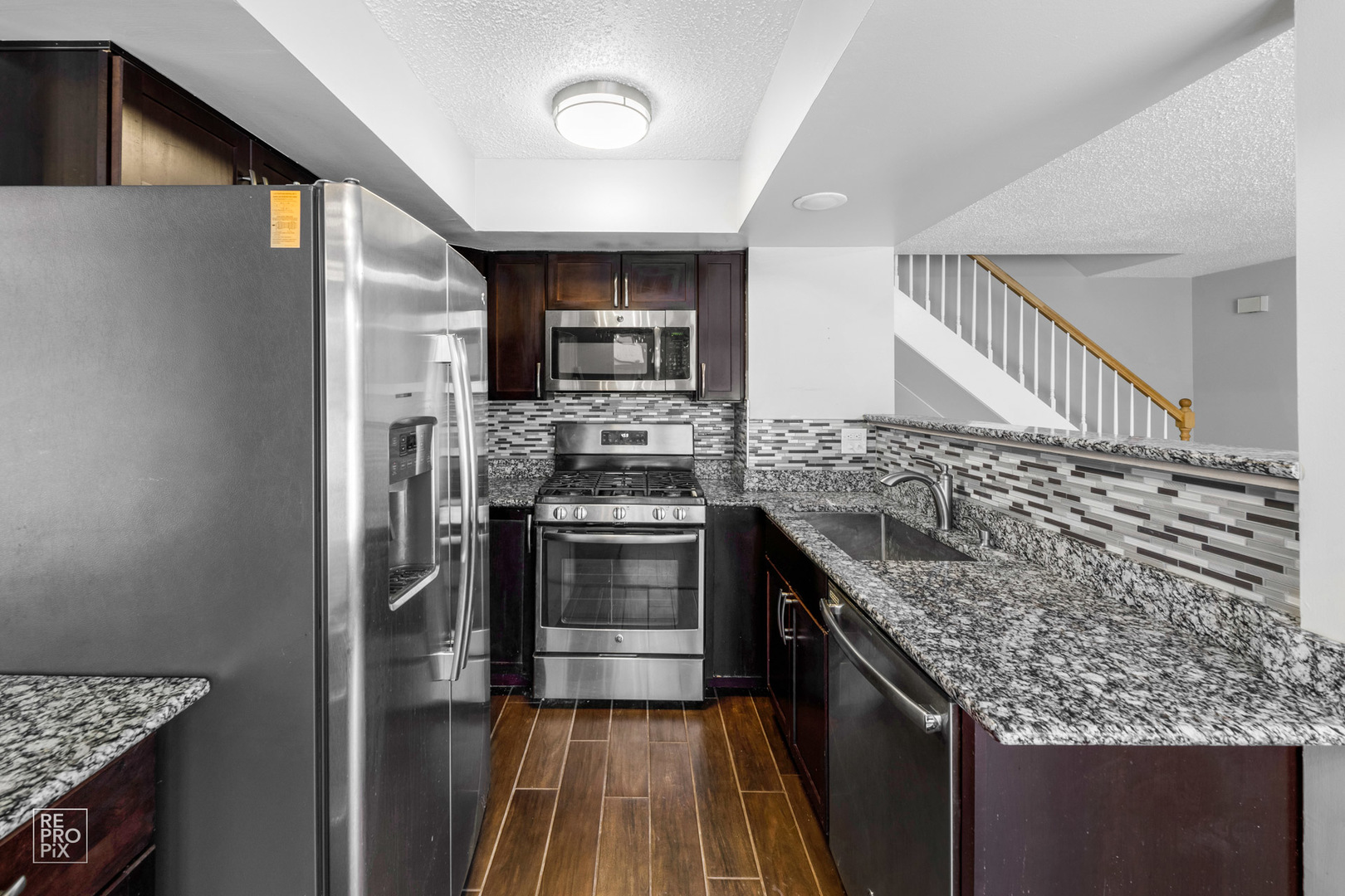1306 Inverrary Lane, Unit 1306 Deerfield, IL 60015 - Photo 5 of 12 a kitchen with stainless steel appliances granite countertop a stove and a refrigerator