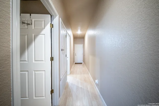 a view of a hallway with wooden floor