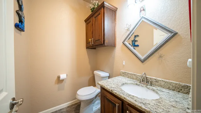 a bathroom with a granite countertop sink and a mirror