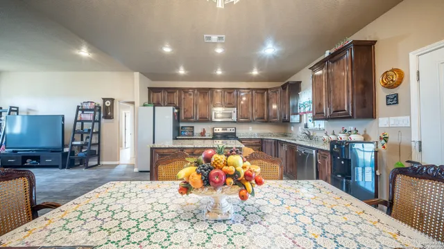 a large kitchen with stainless steel appliances wooden floor and chandelier