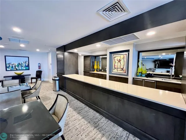 a front view of a building with streets and trees