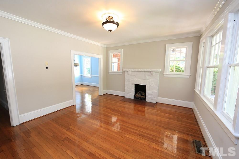 1906 Sunset Drive Raleigh, NC 27608 - Photo 5 of 21 a view of empty room with wooden floor and fireplace