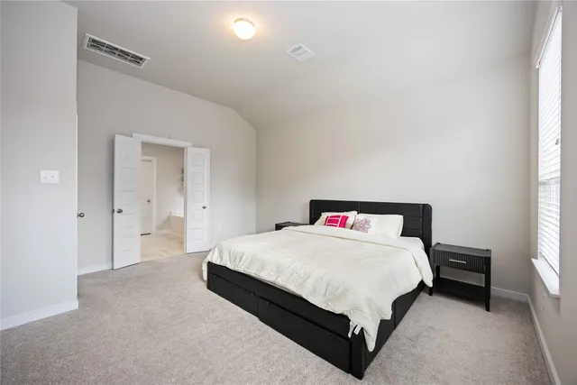 a bedroom with a bed and a window