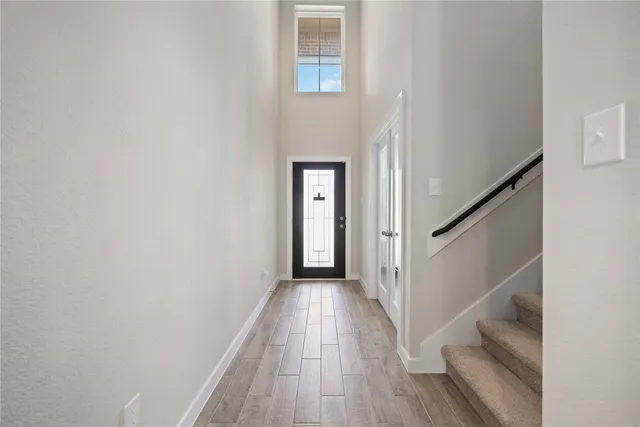 a view of a hallway with wooden floor and entryway