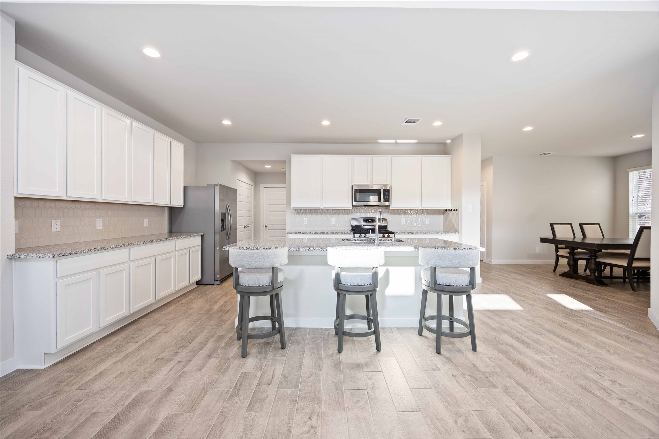 15038 Timberson Rdg Lane Houston, TX 77090 - Photo 10 of 29 a kitchen with a dining table chairs wooden floor cabinets and appliances