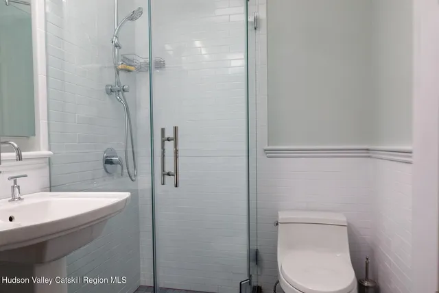 a bathroom with a sink a toilet and shower