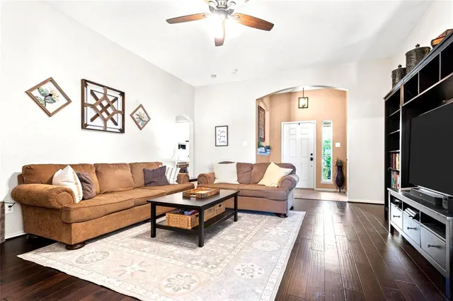 a living room with furniture flat screen tv and wooden floor