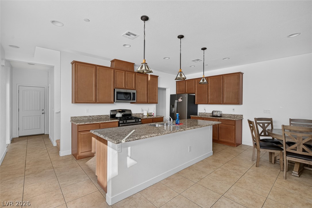 1100 East Sunset Road Henderson, NV 89011 - Photo 9 of 58 A well-appointed kitchen features a central island, rich cabinetry, and a cozy dining nook.