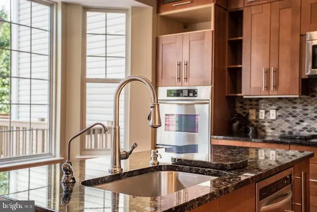 a kitchen with granite countertop a sink and a stove