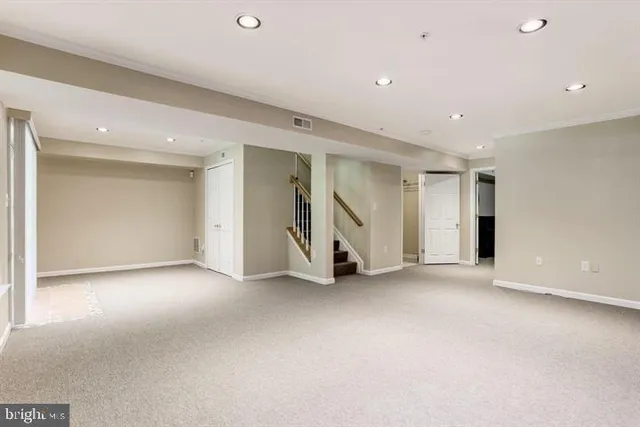 an empty room with a ceiling fan & windows