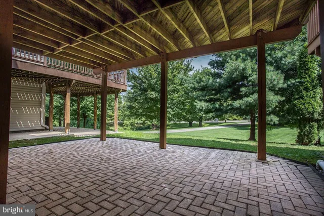 a view of a backyard with table and chairs under an umbrella with a small yard