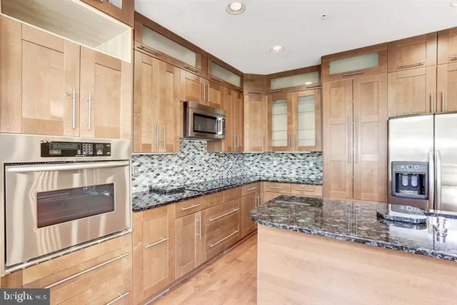 a large kitchen with a large counter top and stainless steel appliances