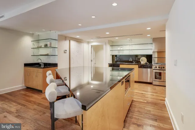 a kitchen with stainless steel appliances a sink a stove top oven a counter space and cabinets