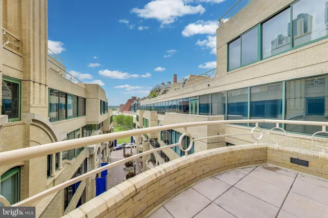 a view of a balcony with a large window and a rug
