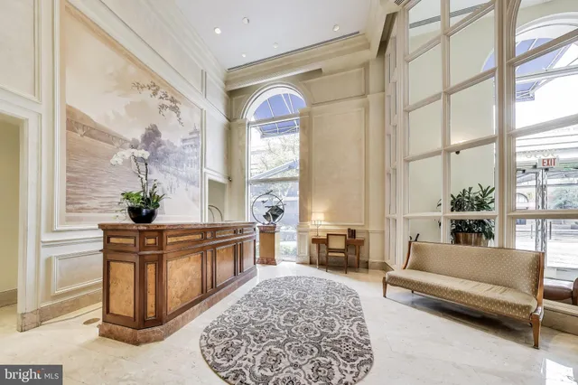 a living room with a couch a dining table wooden floor and a large window