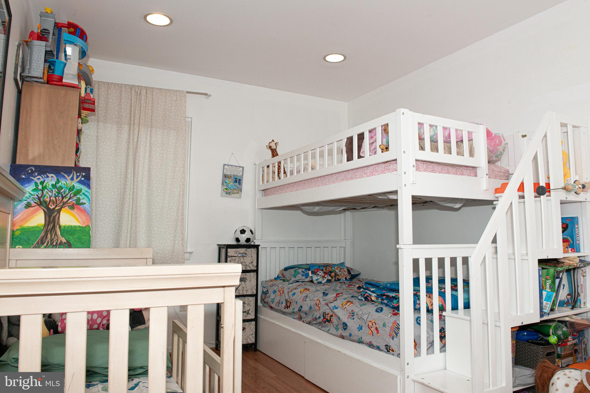 9908 Bustleton Avenue, Unit A8 Philadelphia, PA 19115 - Photo 14 of 24 a bedroom with furniture a baby crib and a window