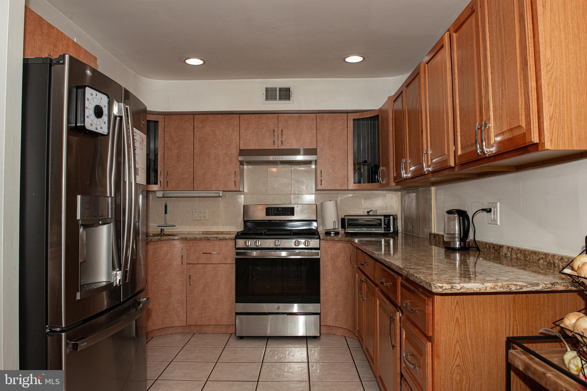 9908 Bustleton Avenue, Unit A8 Philadelphia, PA 19115 - Photo 3 of 24 a kitchen with granite countertop a refrigerator stove and sink
