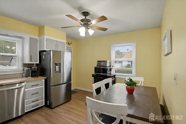a kitchen with stainless steel appliances granite countertop a refrigerator a sink dishwasher stove and refrigerator with wooden floor