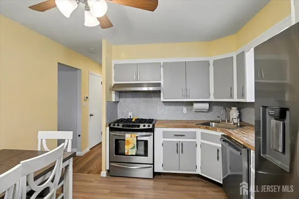 a kitchen with stainless steel appliances a stove a sink and cabinets