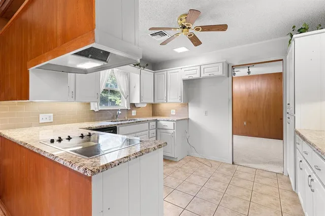a kitchen with a sink window and cabinets