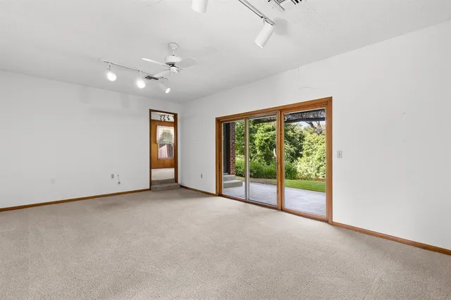 an empty room with windows and ceiling fan
