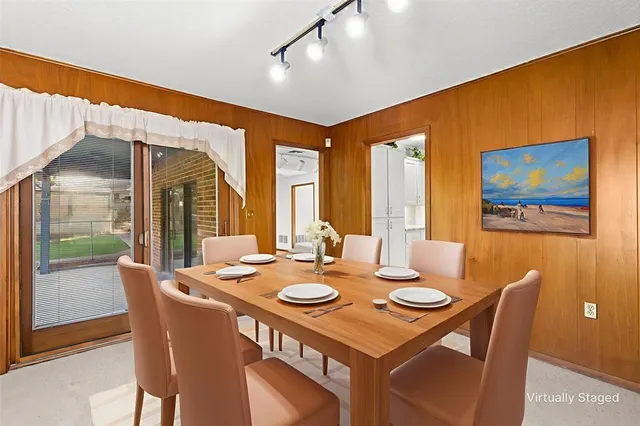 a dining room with furniture a rug and a large window