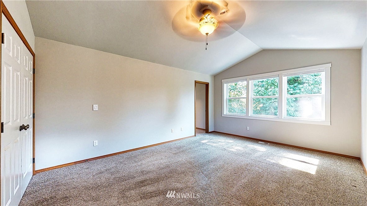 4524 147th Place Southeast Bothell, WA 98012 - Photo 16 of 33 an empty room with a chandelier fan and windows