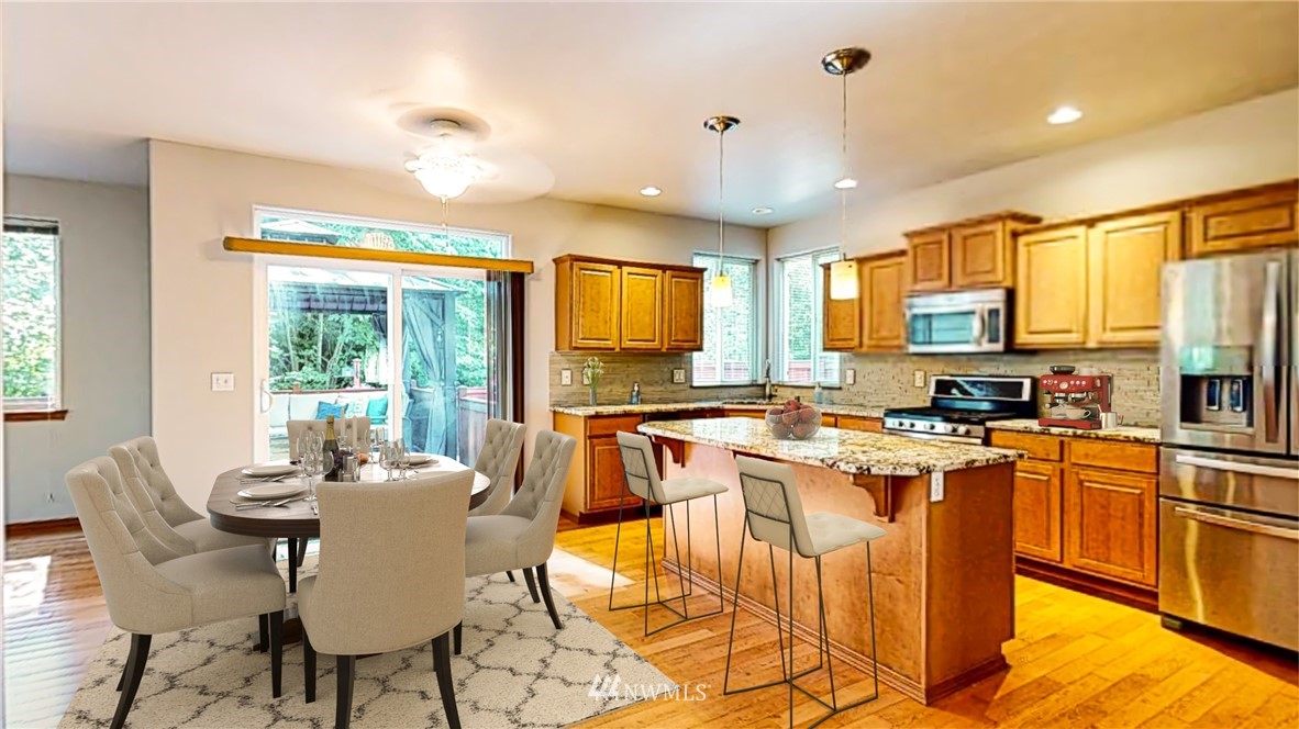 4524 147th Place Southeast Bothell, WA 98012 - Photo 4 of 33 a kitchen with stainless steel appliances granite countertop a stove top oven a sink dishwasher a dining table and chairs with wooden floor
