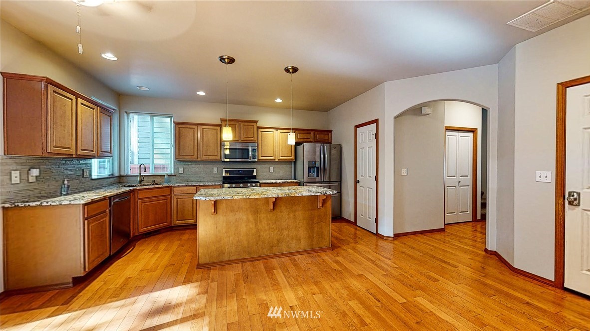 4524 147th Place Southeast Bothell, WA 98012 - Photo 7 of 33 a large kitchen with stainless steel appliances granite countertop a refrigerator and a stove top oven