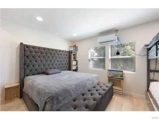 a bedroom with a bed window and table chair