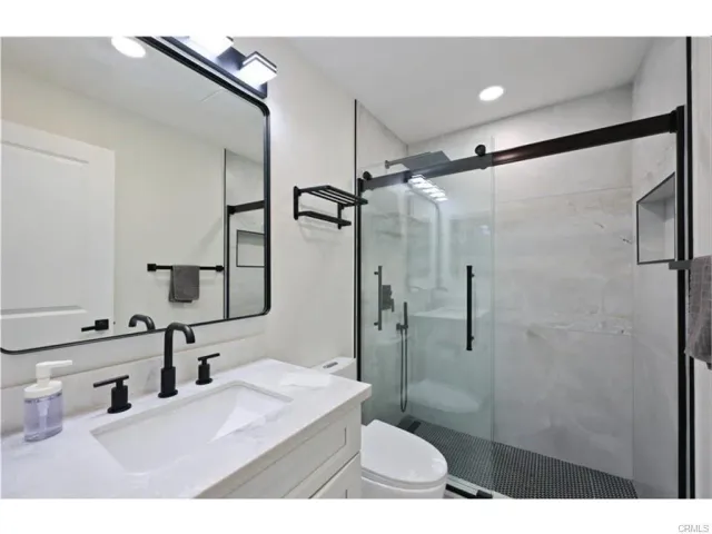 a bathroom with a sink shower and a mirror