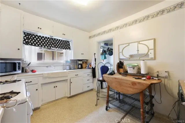a kitchen with a table chairs a sink dishwasher and cabinets