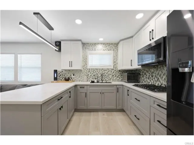 a kitchen with a sink a stove and cabinets