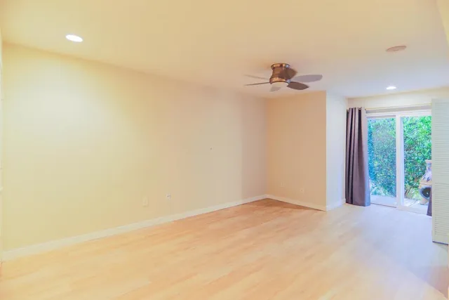 a view of a room with a ceiling fan and a window