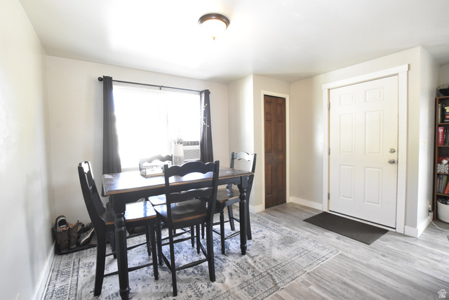 290 West 600 North Logan, UT 84321 - Photo 13 of 45 Dining area featuring a large window, light gray walls, wood-finish flooring, and a white paneled entry door