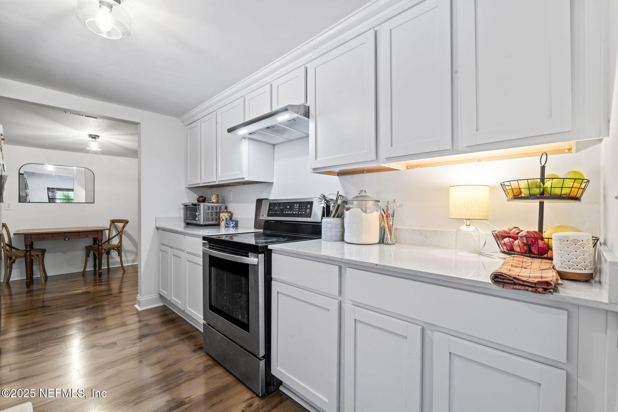 9160 Wild Road Jacksonville, FL 32220 - Photo 12 of 39 a kitchen with stainless steel appliances granite countertop a sink dishwasher stove and white cabinets with wooden floor