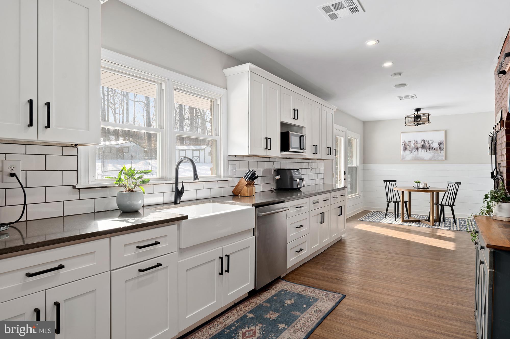 900 Union Church Road Elkton, MD 21921 - Photo 15 of 51 a kitchen with stainless steel appliances white cabinets a sink a stove a dining table and chairs
