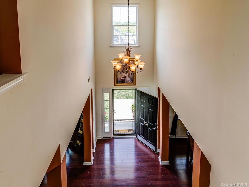 313 Roanoke Road Fletcher, NC 28732 - Photo 15 of 24 a hallway with wooden floor and chandelier