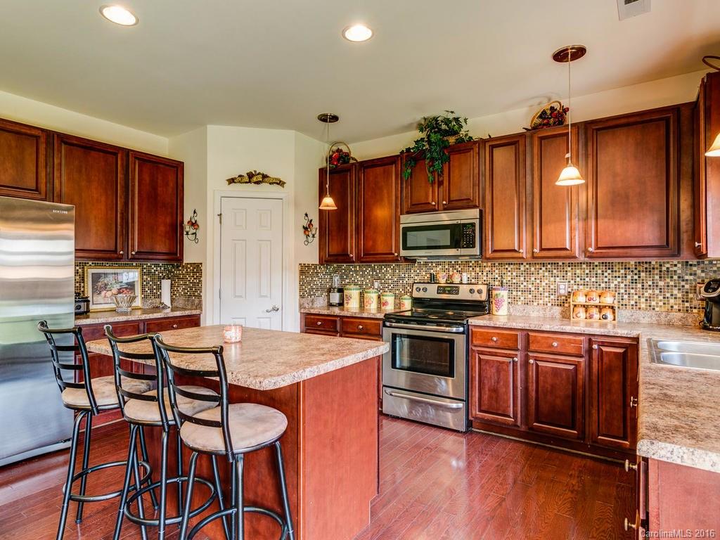 313 Roanoke Road Fletcher, NC 28732 - Photo 9 of 24 a kitchen with granite countertop wooden floors wooden cabinets and appliances