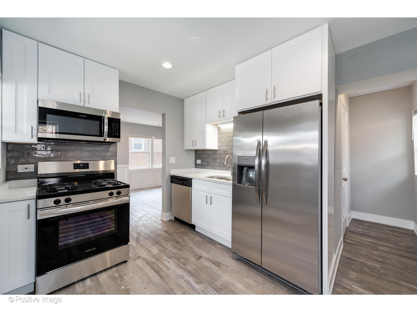 8446 South Constance Avenue Chicago, IL 60617 - Photo 5 of 14 a kitchen with stainless steel appliances kitchen island granite countertop a stove a refrigerator and a microwave