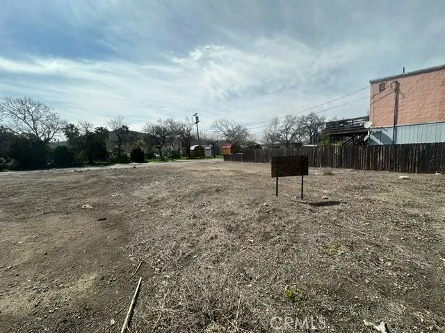 a view of a big yard with wooden fence
