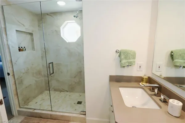 a bathroom with a tub sink and mirror