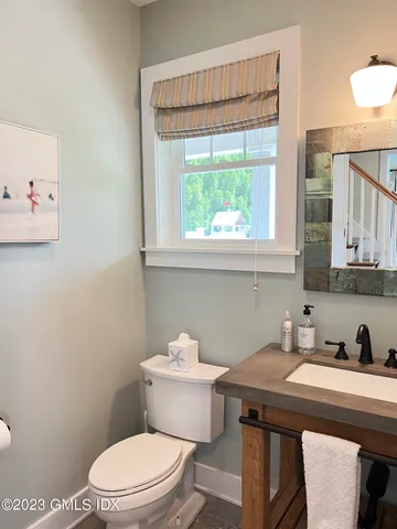 a bathroom with a sink a toilet and a window