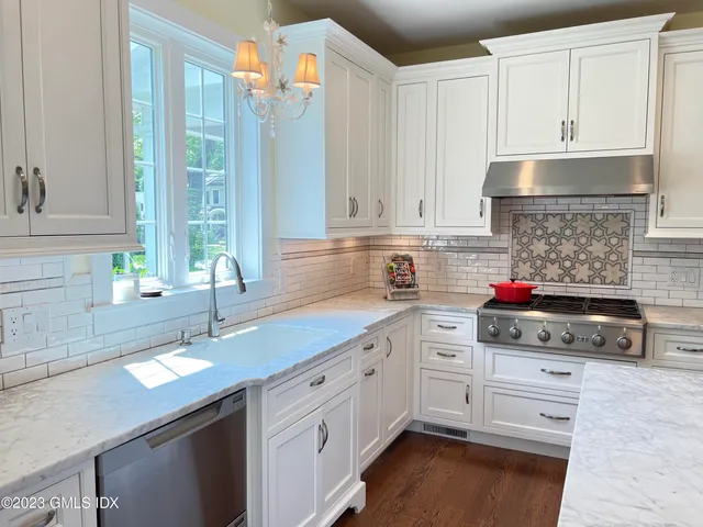 a kitchen with kitchen island granite countertop a sink stainless steel appliances and cabinets