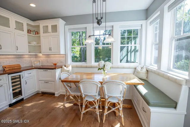 a dining room with wooden floor a chandelier a wooden table and chairs
