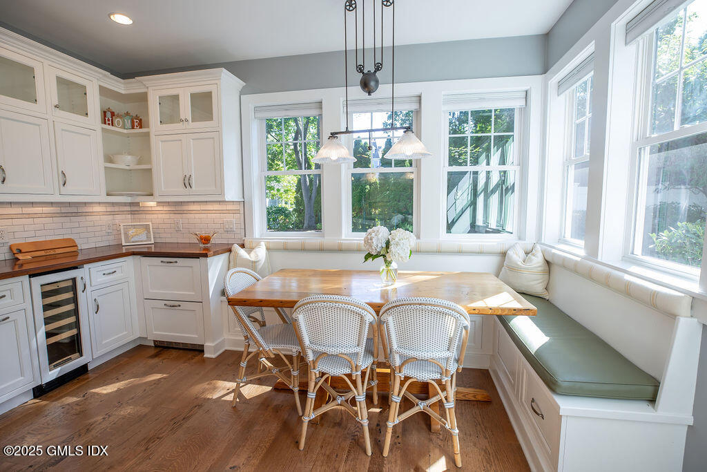 9 Center Road Old Greenwich, CT 06870 - Photo 8 of 26 a dining room with wooden floor a chandelier a wooden table and chairs
